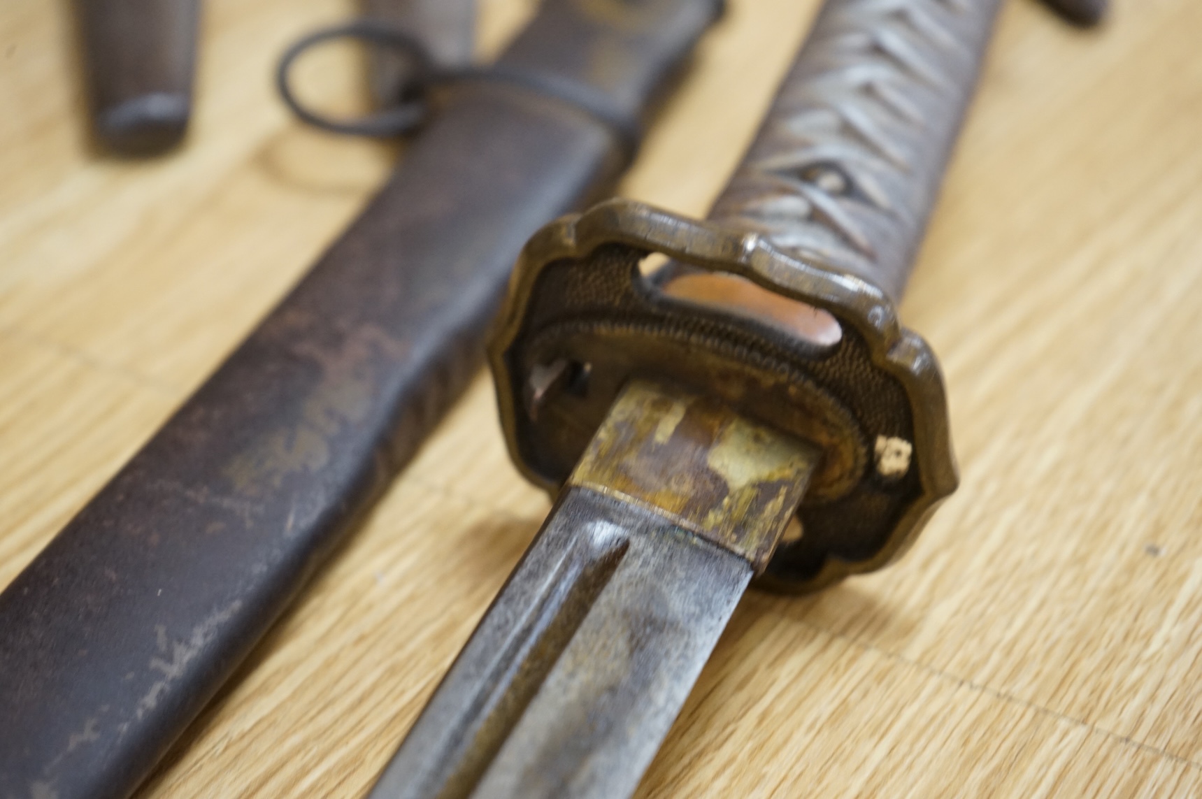 A Japanese World War II NCO‘s sword katana, regulation blade with fuller, stamped 33271, regulation aluminium hilt, brass guard, the spring catch still retains, in an iron scabbard